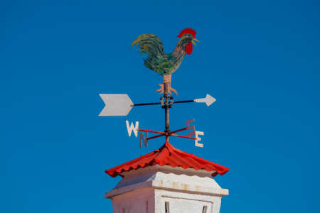Rooster Weathervanes on top of the chimney.の写真素材