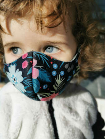 Little Brazilian girl using mask outdoors.の写真素材