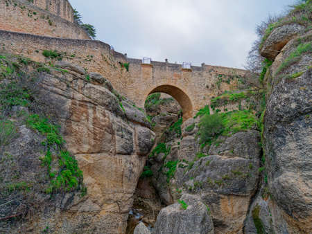 Low angle view of Old Bridge of Ronda, Spain.の写真素材