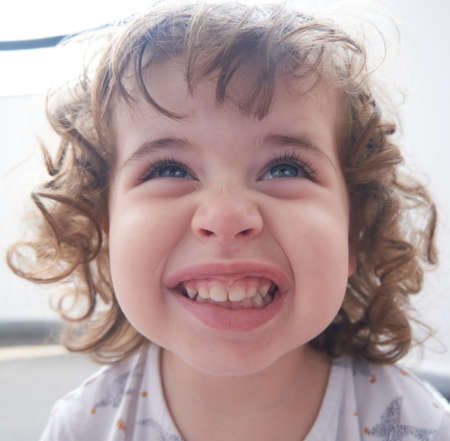 Little Brazilian girl making a smiling face at camera.