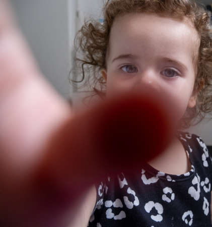 portrait of little girl trying to reach the camera.の写真素材