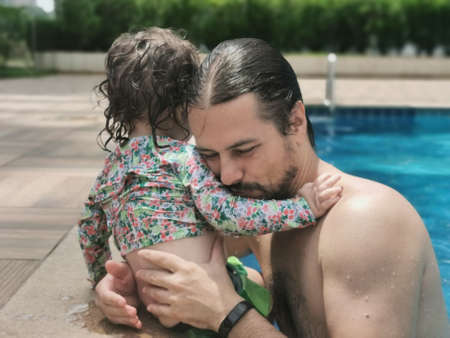 Brazilian Father and Daughter having fun at swimming pool.の写真素材