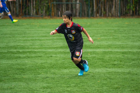 SAO PAULO, BRAZIL - SEPTEMBER 26, 2015: Young Boy running on the football field during the rainのeditorial素材