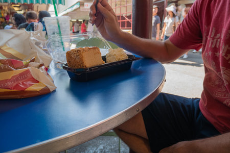 LOS ANGELES, USA - JUNE 28, 2016: Man having a cheesecakes slice in Los Angles market.のeditorial素材