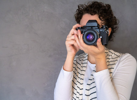 View of a beautiful woman taking pictures with professional camera with copy space.の写真素材