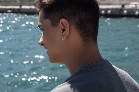 Back view teenager smiling in the port of Malaga looking at the sea