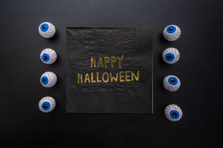 Funny Halloween treat - Candy eyeballs with a Napkin written "Happy Halloween" on dark background. Copy space.の写真素材