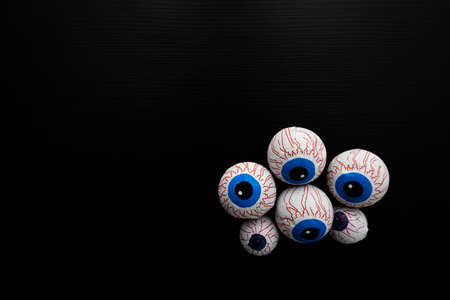 Funny halloween treat - Candy eyeballs on dark background. Copy spaceの写真素材