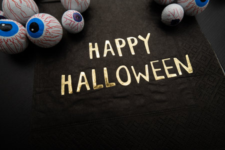 Funny Halloween treat - Candy eyeballs with a Napkin written "Happy Halloween" on dark background. Copy space.の写真素材