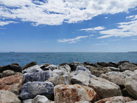 View of the Mediterranean sea hitting rocks on the beach..