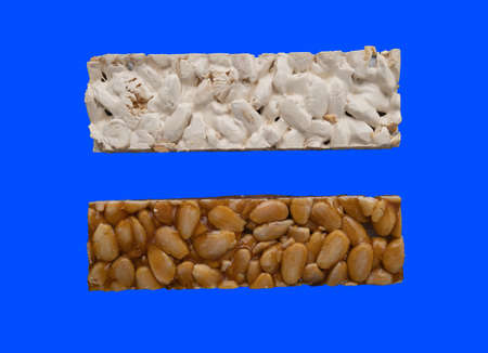 Top view of 2 different types of Spanish Turrons on blue background.