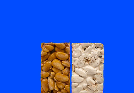 Top view of 2 different types of Spanish Turrons on blue background.