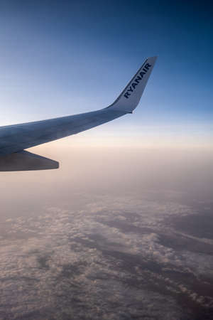 VIENNA, AUSTRIA - JULY 09, 2021: Beautiful view through the airplane window to the wing with Ryan Air logo.のeditorial素材
