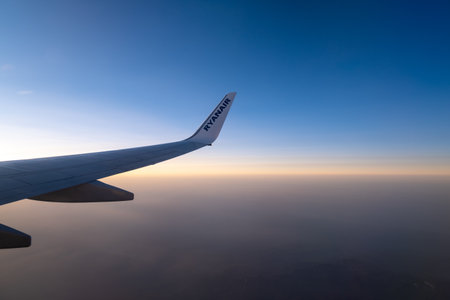 VIENNA, AUSTRIA - JULY 09, 2021: Beautiful view through the airplane window to the wing with Ryan Air logo.のeditorial素材