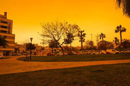 Malaga, Spain - March 24, 2022: Apocalyptic vision of the muddy sky in Malaga due to the arrival of the Saharan fog with no filter.の写真素材