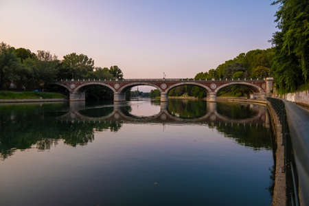 Beautiful sunset view of the arch bridge over the river Po in the city of Turin, Italy.の写真素材