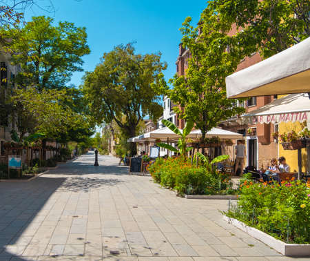 VENICE, ITALY - August 27, 2021: View of families having lunch in a typical Italian restaurant on the streets of Venice.の写真素材