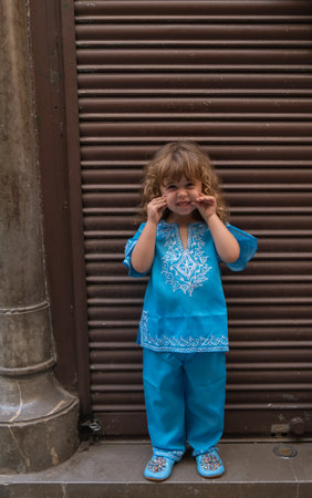 Beautiful blonde girl in arab costumes posing for camera in the streets of Granada, Spainの写真素材
