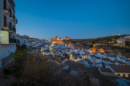 Andalucian village with white houses built into rock at nightの写真素材