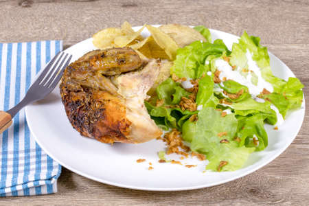 plate of roast chicken, crisps and green salad