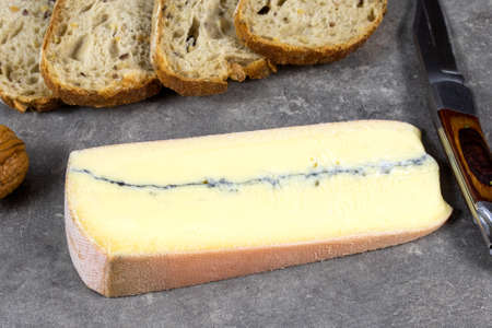 slice of Morbier cheese and bread on a table