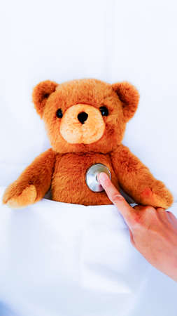 sick teddy bear lying in a bedの写真素材