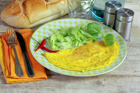 omelette with herbs and salad in a plate