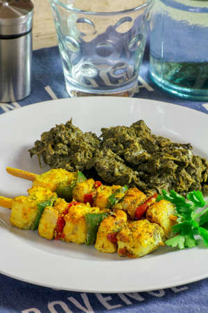 Fish skewers and grilled peppers on a plate