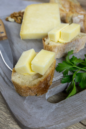slice of Cantal cheese on a cutting boardの写真素材