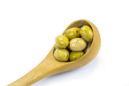 wooden spoon filled with green olives marinated in thymeの写真素材
