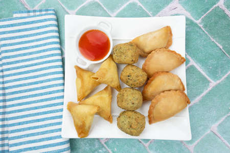 plate of samosa, accras and fried donut