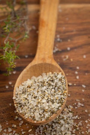 wooden spoon with mixed salt and dried spices on wooden backgroundの写真素材