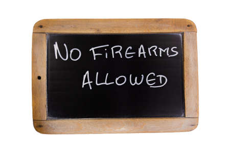 slate with writing on it in English no firearms allowed, isolated on a white backgroundの写真素材