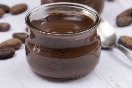 small glass jar of chocolate cream on a table