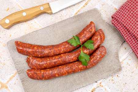 several raw merguez on a cutting boardの写真素材
