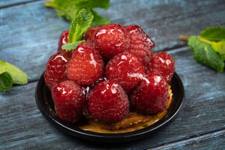 raspberry tartlet on a gray background
