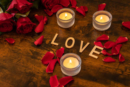 valentine's day background with burning candles and rose petals.の写真素材