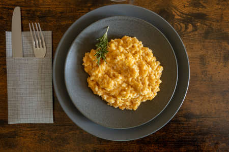 butternut risotto in a plate on a wooden backgroundの写真素材