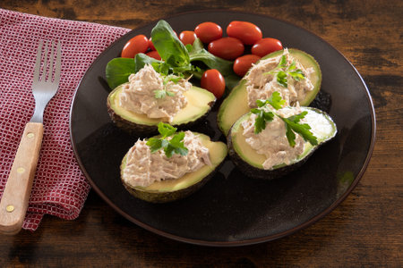 salad with avocados, tomatoes and basil on a wooden backgroundの写真素材