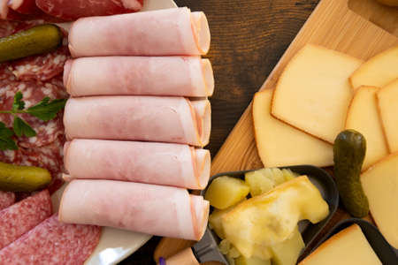 plate of charcuterie cheese for a raw and fondue raclette on a tableの写真素材