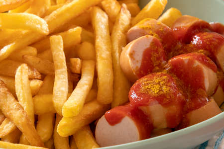 close up of cervelas curry wurst in piece in a plate with french friesの写真素材