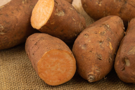 close up of whole and cut sweet potato on burlapの写真素材