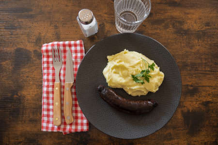 top view of cooked black pudding with mashed potatoes in a plate on a tableの写真素材