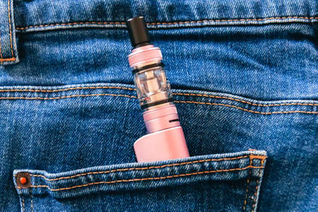 electronic cigarette in the pocket of jeans close-up