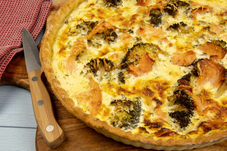 top view of a whole broccoli salmon pie on a wooden boardの写真素材