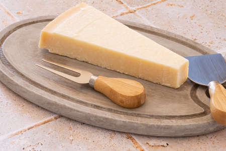 piece of parmesan cheese on a wooden board