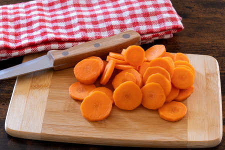 fresh sliced carrots on wooden boardの写真素材