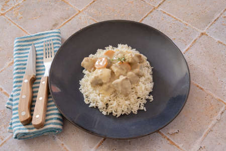 veal cooked with mushrooms and carrots mixed with rice on a plateの写真素材