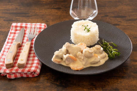 veal cooked with mushrooms and carrots with rice on a plateの写真素材