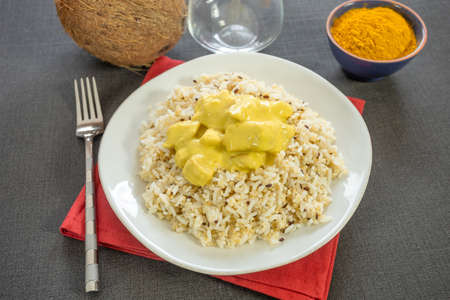 top view of chicken in coconut milk and curry with rice on a plateの写真素材